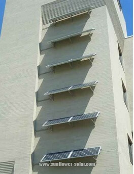 a set of photovoltaic panels mounted on the south wall of a college classroom building набор фотоэлектрических панелей, установленных на южной стене здания колледжа